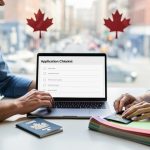 A Canadian couple reviewing immigration documents at a table with a laptop, passport, and organized folders, suggesting preparation for a spousal open work permit application.